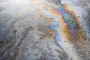 Oil gleaming with rainbow hues in contaminated water.