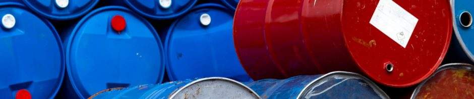 A massive stockpile of blue and red industrial drums, representing the safe and compliant waste transportation and hazardous waste management of chemical, oil, and liquid materials.